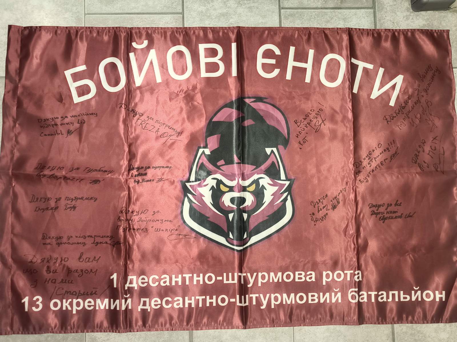 Ukrainian ensign with patch signed by fighters of 1st Airborne Assault Company (Combat raccoons)